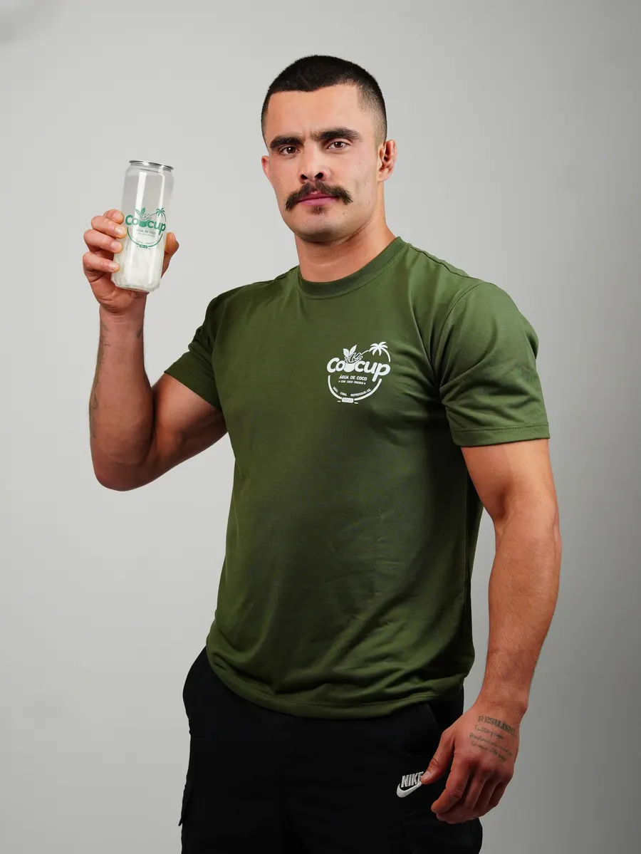 Homem de camiseta verde com o logo da Cocup segurando um copo de Cocup