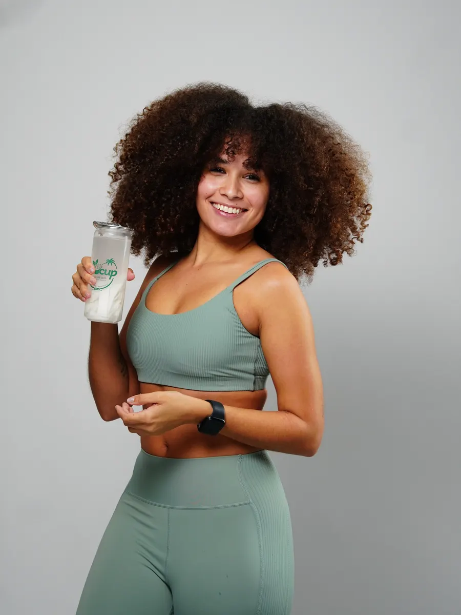 Mulher sorrindo com um copo de Cocup na mão